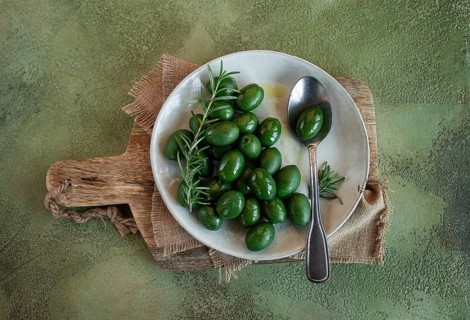 Chalkidiki olives, classic Greek green olive, on a plate, with a spoon, top view, no people