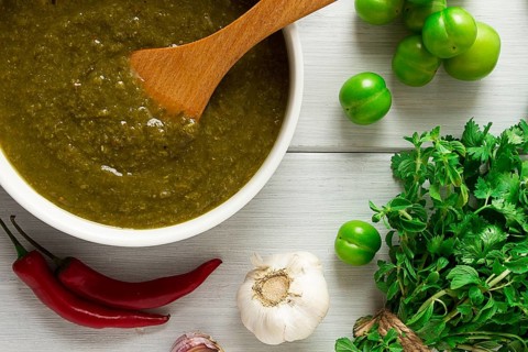 Tkemali sauce, traditional Georgian cuisine, green cherry plum, with ingredients for sauce,