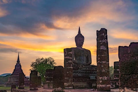 Sunset at a Buddha statue of the temple Wat Mahathat, UNESCO World Heritage Sukhothai Historical