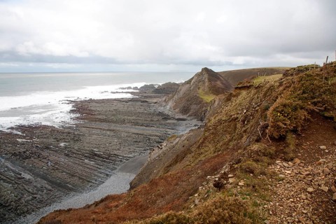 Rocky wave cut platform erosional landforms with ridges formed by eroded tilted strata at Hartland
