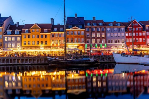 Colourful houses, restaurants and historic ships on the Nyhavn canal and harbour at dusk,