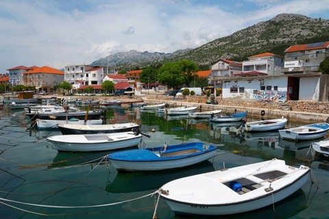 Various boats in a harbour surrounded by mountains and a quiet village panorama, Starigrad,