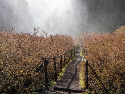 Waterfall Salto El Leon, path leading behind water veil, valley of waterfalls east of Pucon, La