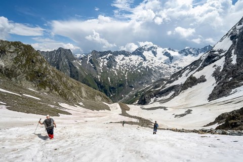 Mountaineers hiking in a snowfield, Nördliche Mörchnerscharte, behind mountain peak Kleiner