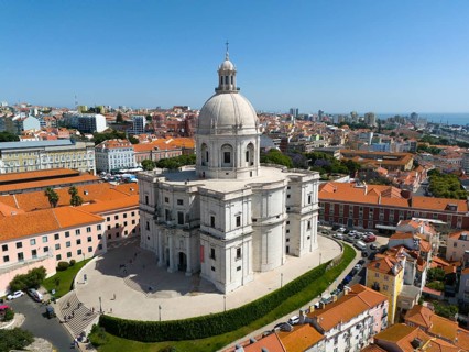 Central dome-shaped building in the foreground of a dense urban environment on a clear day,