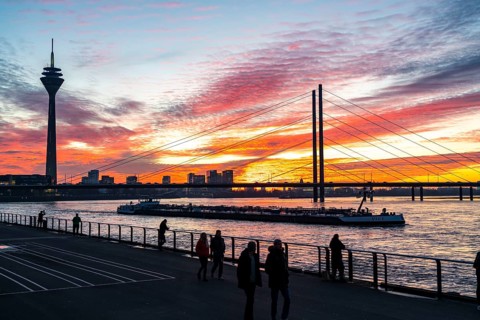 Winter sunset on the Rhine near Düsseldorf, riverside promenade at the old town, Rhine Tower, cargo