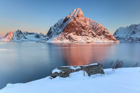 Snow-covered mountains reflected in the fjord at sunrise, winter, Reine, Moskenesoya, Lofoten,