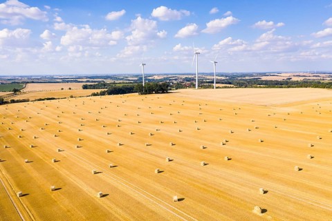 Straw bales on a harvested grain field from above, wind turbines in the background, Nossen, Saxony,