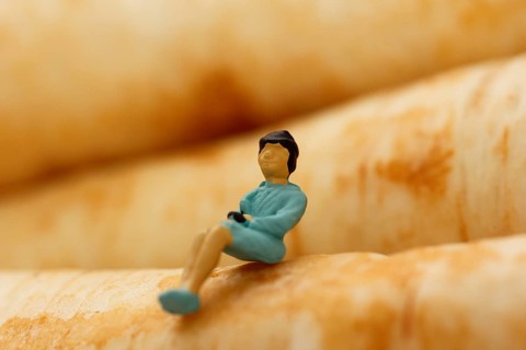 Miniature figure of a woman sitting on parsley root (Petroselinum crispum), root parsley, North