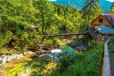 Wooden bridge and restaurant above radovna river flowing through vintgar gorge near bled, slovenia,