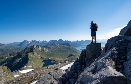 View of mountains and fjord landscape, mountain panorama, mountaineer at the summit of Rundfjellet,