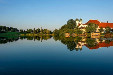 Romanesque Benedictine abbey Seeon monastery, monastery church St. Lambert with reflection in the