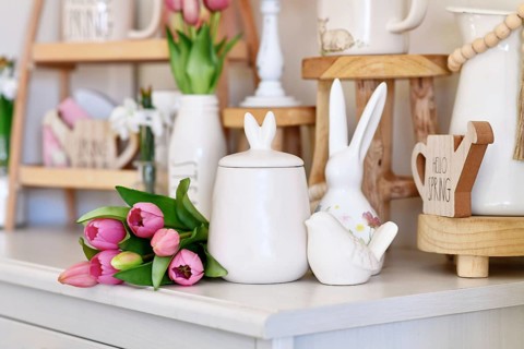 Cute seasonal Easter decor with small canister with bunny ears, bird and pink tulip flower boquet