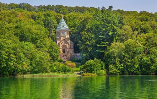 Votive chapel Memorial Chapel of St Ludwig on the lakeshore with wooden cross in the lake, the