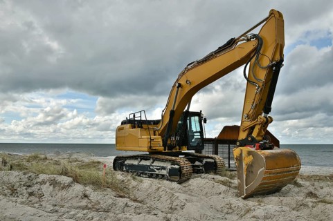 Excavators working to reclaim land on the beach of the Darß peninsula, Mecklenburg-Western