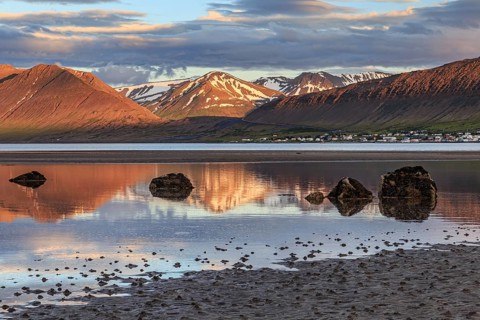 Fjord, low tide, stones, mountains reflected in the water, evening light, cloudy mood, Thingeyri,