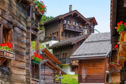 Old wooden houses with flower boxes in front of windows and balconies in the historic village