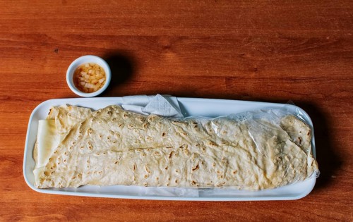 Delicious traditional Nicaraguan quesillo served on wooden table, View of a Nicaraguan quesillo