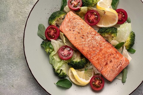Grilled salmon fillet, with vegetables, broccoli, cherry, iceberg lettuce, spices and herbs,