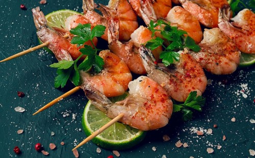 Shrimp kebab, with spices, lime, on wooden skewers, top view, no people