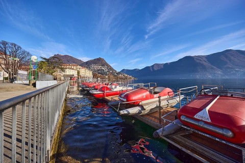 Pedal boats, metal railing, lake, shore, pavement, pedal boat rental, mountain landscape, haze,