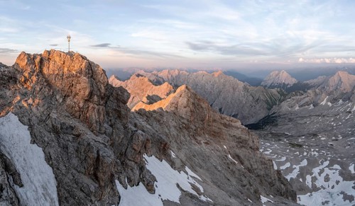 Summit of the Zugspitze with golden summit cross, alpenglow at sunset, Northern Limestone Alps,