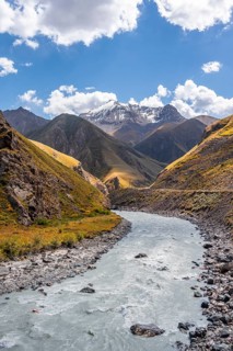 Mountain river in a valley, picturesque mountain landscape with white mountain peaks, Tian Shan