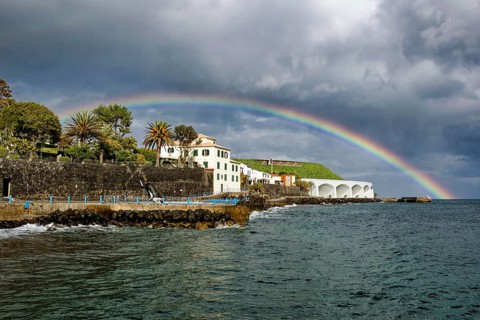 Promenade in rainy weather with rainbow on the beach of the Atlantic Ocean, municipality of Santa
