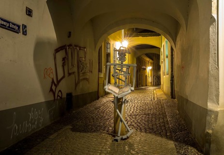 Passageway from Brüderstraße into Schwarze Straße with abstract figure of a reader at night,