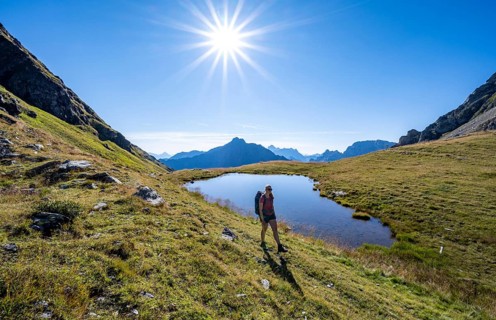Hiker on the Carnic High Trail, small mountain lake, Carnic Main Ridge, Carnic Alps, Carinthia,