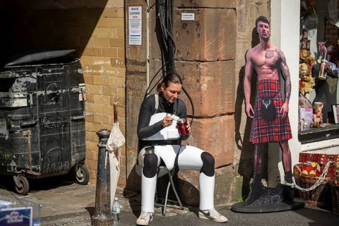 Participant taking a lunch break, world's largest cultural festival The Fringe, High Street,
