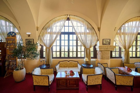 Cosy interior with large windows, curtains, seating areas and warm lighting, Elafos Hotel, Profitis