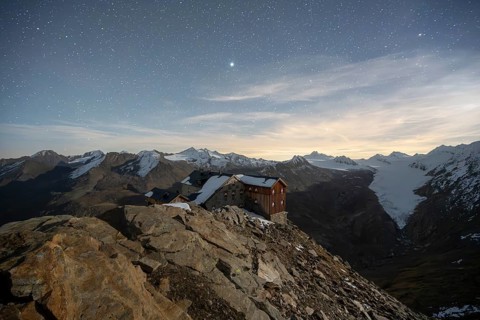 Mountain landscape under a starry sky, night shot, mountain hut Ramolhaus in autumn with snow, view