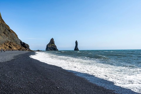 Black beach with cliffs, rock Reynisdrangar in the water, at Reynisfjara beach, Vik, South Iceland,