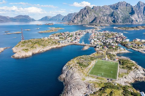 Aerial view over fishing village Henningsvaer, football stadium on rocky island, Lofoten, Norway,