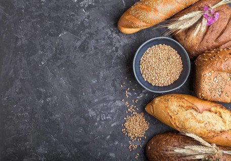 Different kinds of fresh baked bread on a black concrete background. top view, flat lay, copy space