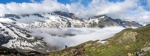 Mountaineer on a hiking trail with high fog in the valley, summit Hochfeiler, Hoher Weißzint and