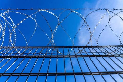 Symbolic image security, S-wire rolls, NATO wire, on a fence top, demarcation of a property,