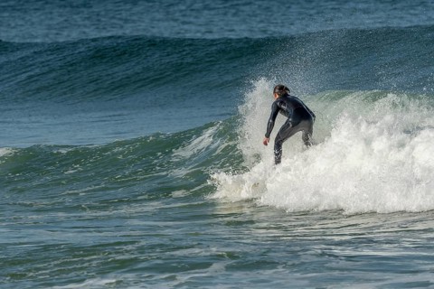 Surfer riding a wave on an Atlantic Ocean beach. Camaret, Crozon, Brittany, France, Europe