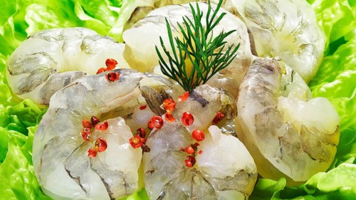 Some raw shrimps, prawns, decorated on lettuce leaves with dill and Pink Pepper berries, red
