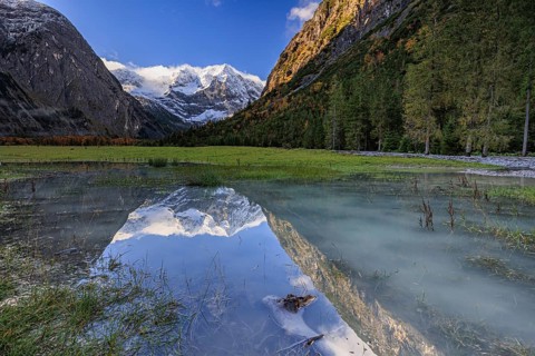 Snow-covered mountains reflected in lake, pond, autumn, Großer Ahornboden, Karwendel Mountains,