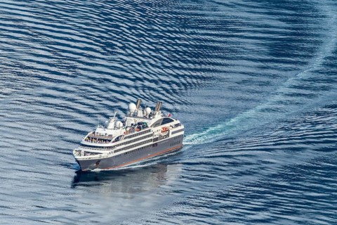 Cruise ship L'Austral leaving the Geirangerfjord into fjord Synnylvsfjord, seen from viewpoint at