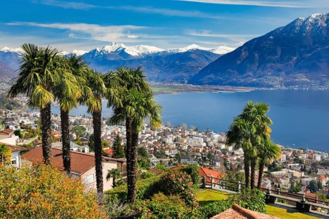 View over the city of Locarno and Lake Maggiore with snow-capped mountains in the background,