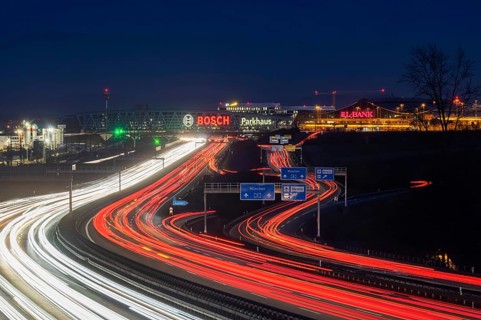 A8 motorway at Stuttgart Airport in the evening. Heavy traffic, lanes of light. Modern architecture