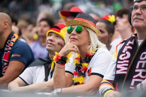 A woman watches the football match in the fan zone at the Brandenburg Tor during the quarter-final