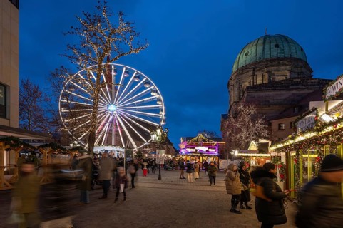 Ferris wheel at the winter village, Christmas market at dusk, St Elisabeth's Church on the right,