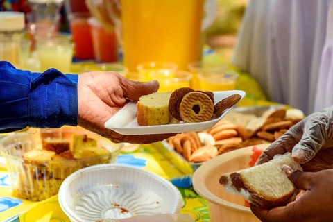 Person receiving various foods in a tray at a community breakfast Belo Horizonte, Minas Gerias,