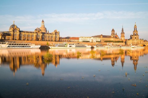 Silhouette of the Old Town with reflection in the Elbe in the morning, steamboats on the