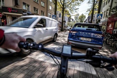 Cycling in the city, inner-city street, cycle lane, bicycles have priority, two-lane traffic with