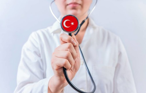 Female doctor holding stethoscope with Turkey flag. National Health System of Turkey